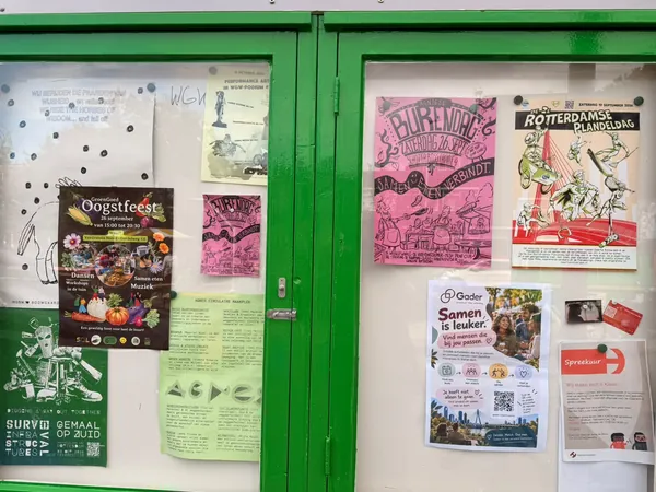 Het groene buurtprikbord, met onze flyer tussen de affiches van de wijk.