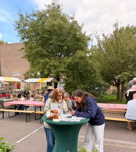 Bezoekers bekijken de flyers aan onze tafel.